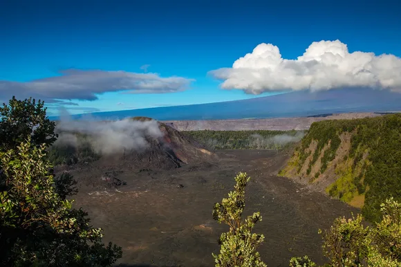 Volcanic crater with a large cinder cone on the left-hand side and a larger mountain beyond.